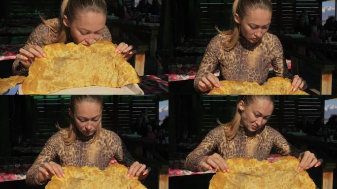 吃国家布里亚特蒙古菜cheburek的女人。大xxxl 68厘米heburek用奶酪肉洋葱煎入油锅中