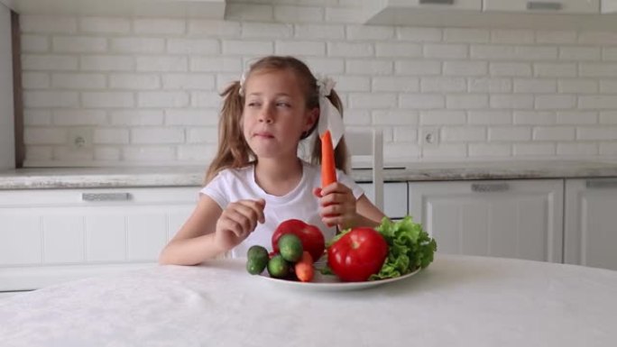 孩子高兴地吃蔬菜。小女孩在厨房里吃胡萝卜。健康饮食的概念