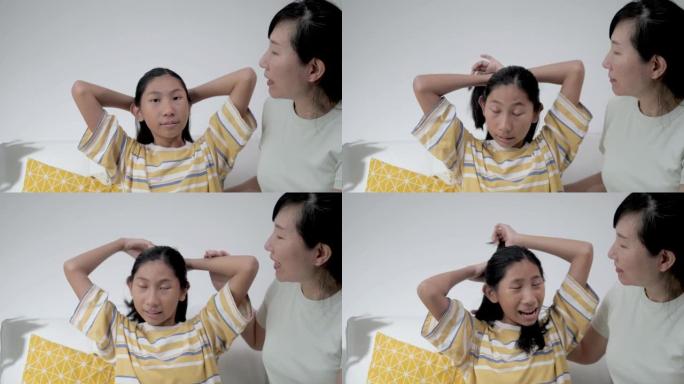 快乐的亚洲女孩和母亲在家坐在沙发上刷牙和打结，生活方式理念。