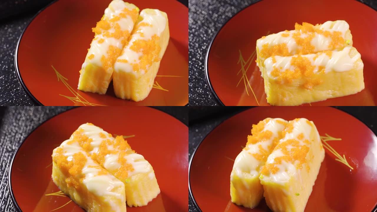 寿司配蛋卷和蛋虾配甜奶油放在转盘上。海鲜配料的日本食物。宏观拍摄。