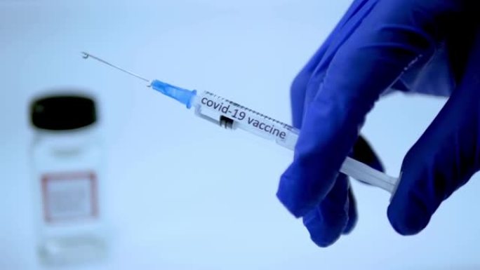 预防冠状病毒感染的疫苗，医生演示了大流行的治愈方法，注射器与新型冠状病毒肺炎药物，特写