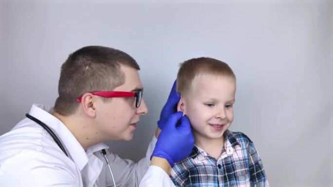 耳鼻喉科医生检查了一个抱怨疼痛的男孩的耳朵。疼痛缓解和治疗理念。耳道或鼓膜发炎。儿科医生的检查。
