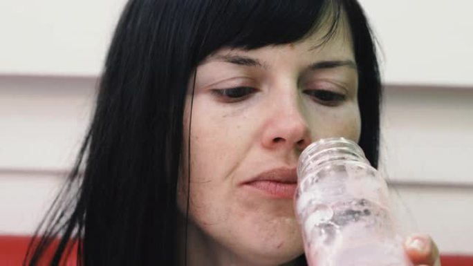 喝。女人喝塑料瓶里的果汁。