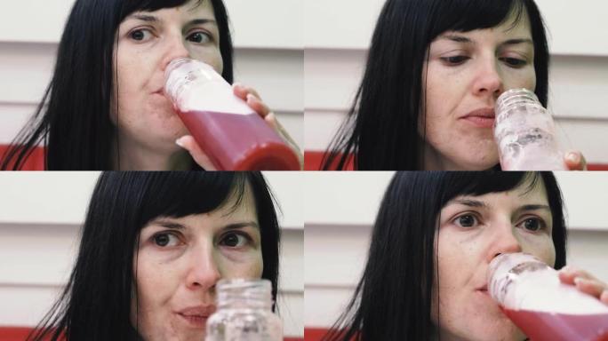 喝。女人喝塑料瓶里的果汁。