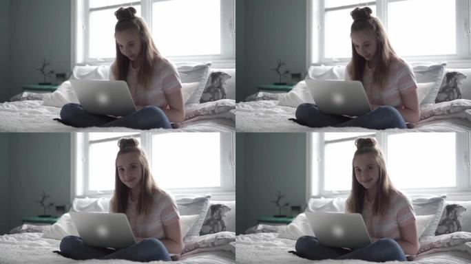 一个年轻的少女躺在床上，手提电脑