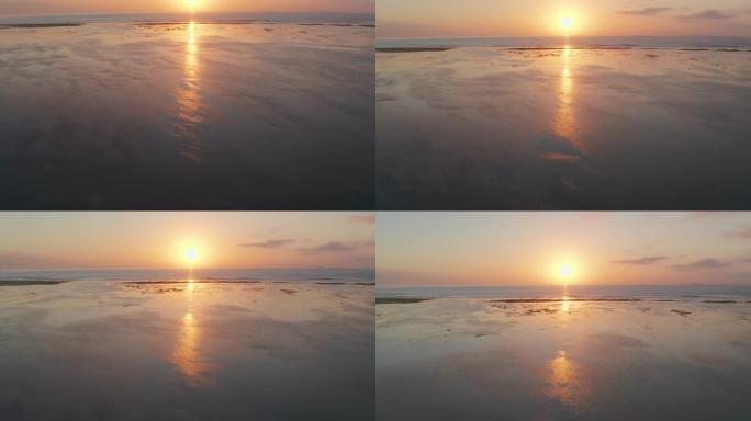 无人机在退潮海滩上朝着海上日出