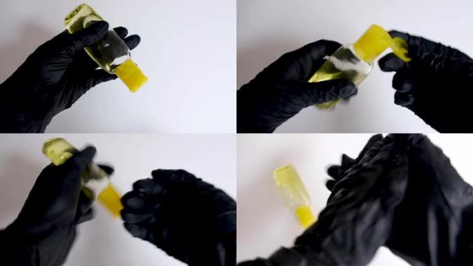 戴着黑手套，用黄色瓶子里的消毒液洗手。