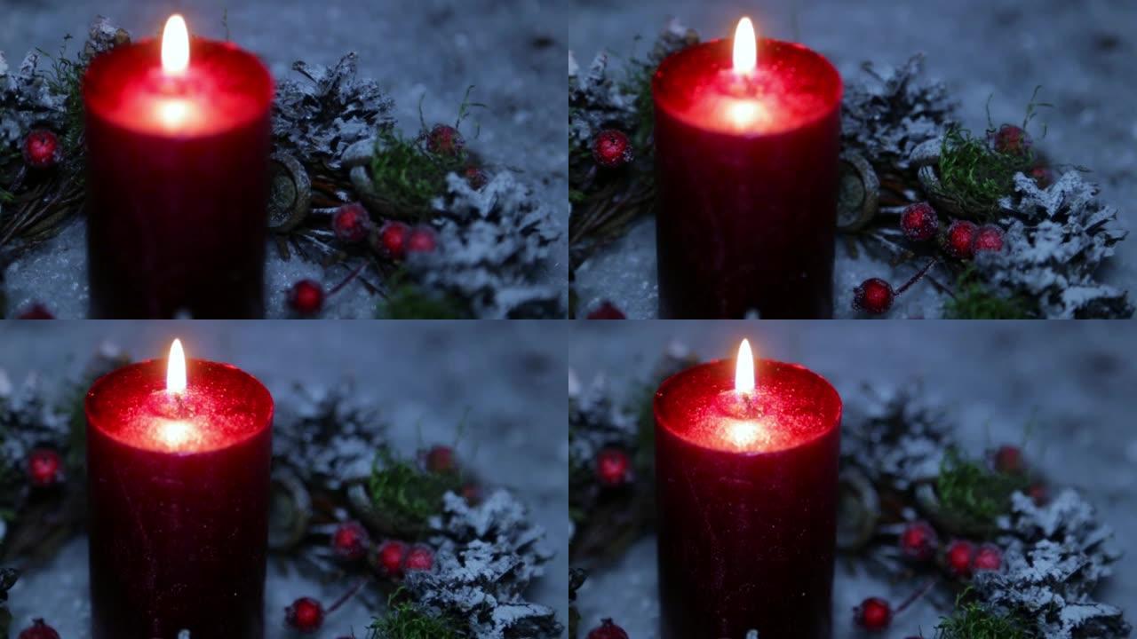 在人造雪的背景下，圣诞节之夜点燃的蜡烛