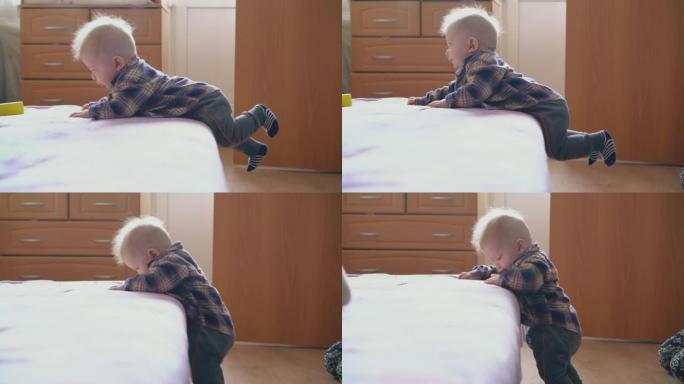 有趣的婴儿从房间地板上的大软床上下来