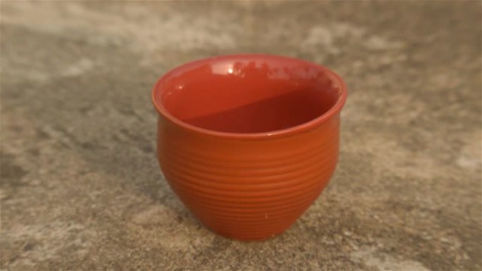 日落灯光下的咖啡杯 (Bhar)。夏天清新凉爽。泥泥茶杯用粘土制成，用于在带有阳光阴影的住宅建筑的粗
