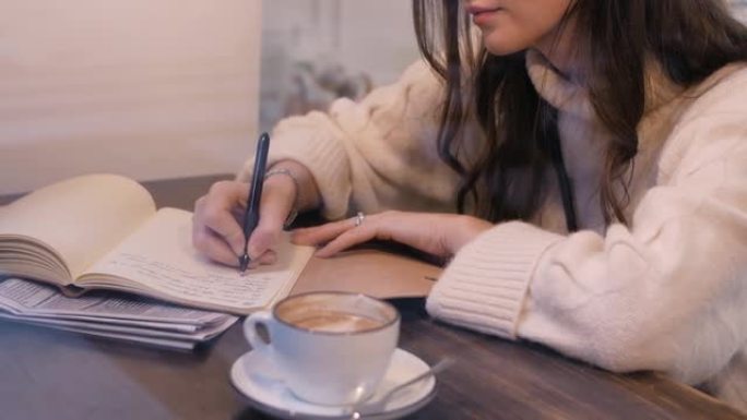 美女作家坐在咖啡馆里写诗
