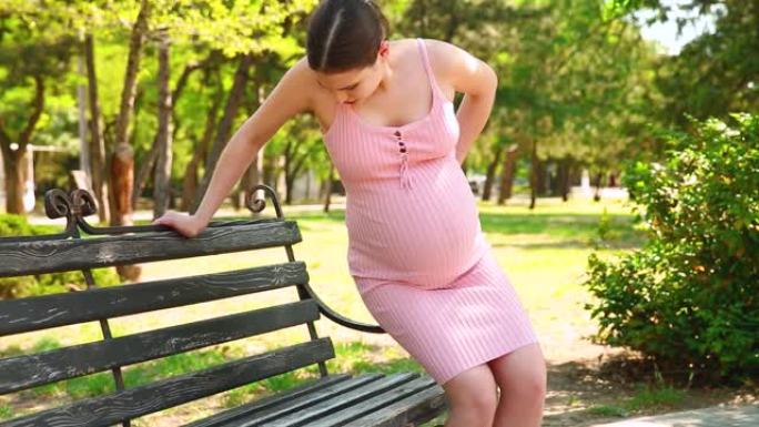 一名孕妇因剧烈疼痛坐在长凳上