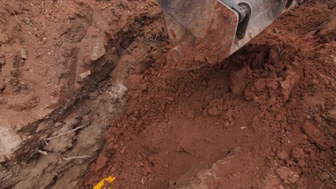 挖掘机在地面上埋设管道，管道覆盖有套管
