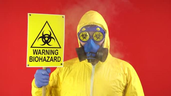 显示出警告生物危害的迹象。一个穿着黄色防护服，戴着横幅的防护面具的人。危害概念，生态问题。