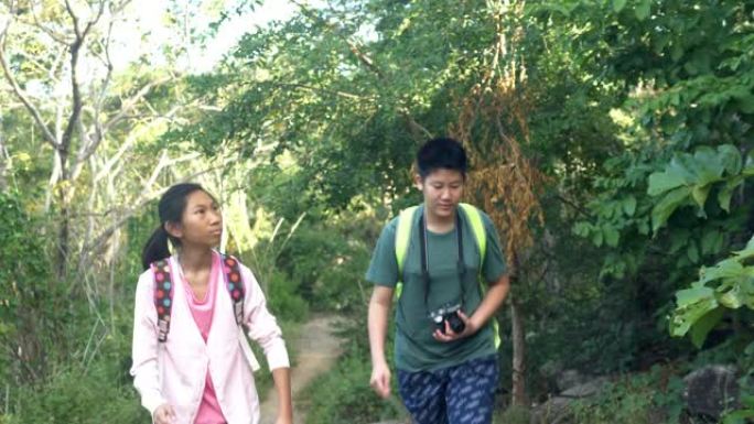 快乐的亚洲儿童一起在森林里散步，生活理念。