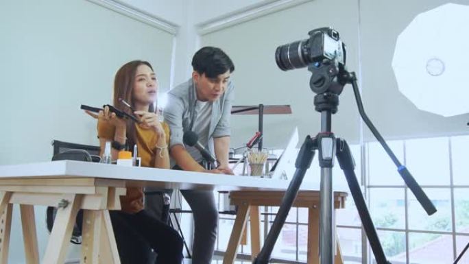 亚洲年轻夫妇博客录制vlog视频，有影响力的人在工作室用化妆化妆品在社交媒体上直播，在线学习教程