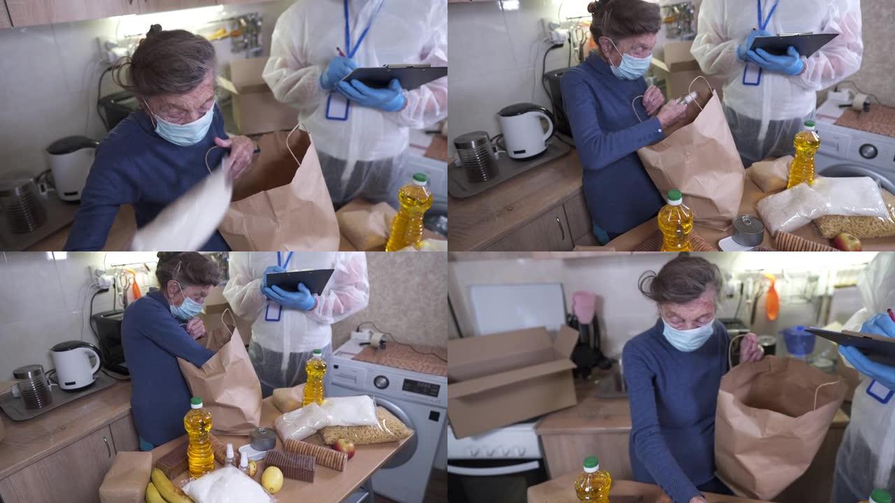 在新型冠状病毒肺炎冠状病毒流行期间，身穿细菌防护服和防护口罩的男子向检疫的老年人运送食物。捐赠箱，里