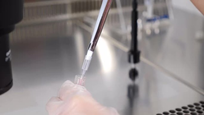 计划生育诊所现代科学实验室胚胎冷冻保存。在实验室操作过程中使用移液器的生殖学家医生。医生从烧瓶中提取