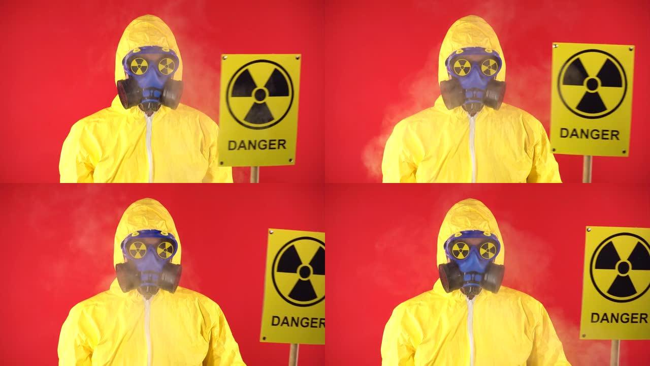 一个穿着防护化学服的男人，戴着防护面具，海报辐射着一对夫妇。隔离，工作室拍摄。红色背景上的辐射危害概