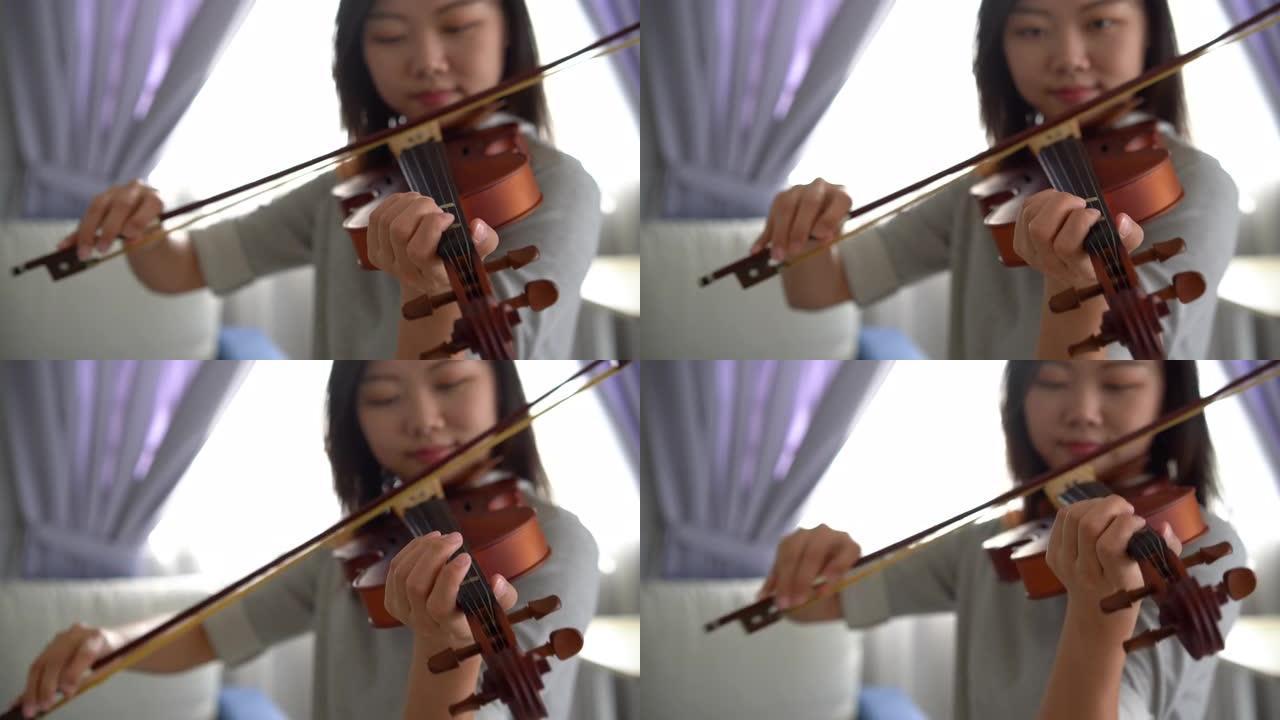 一名亚裔华裔女子在家拉小提琴