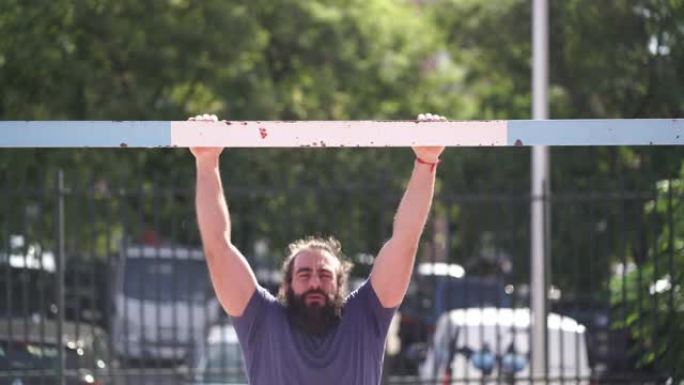 健康的大胡子男子训练在公园的足球球门上做俯卧撑