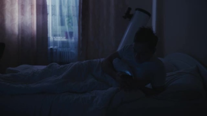 男子在床上与智能手机