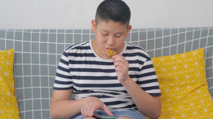 青少年在智能手机上玩游戏，在家吃零食。