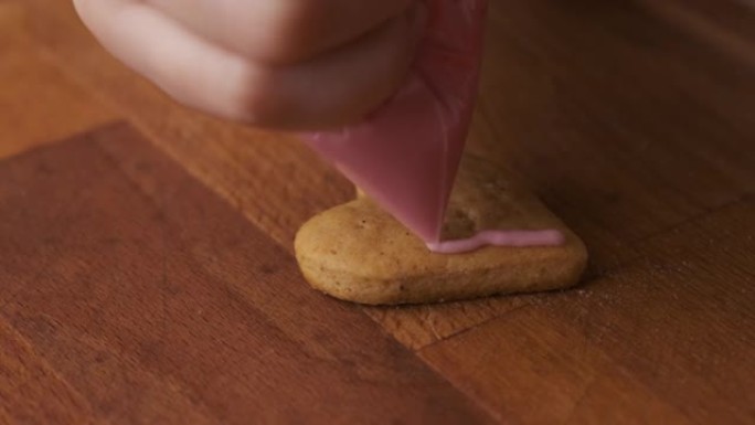 情人节用粉红色釉面装饰姜饼或饼干在木桌上