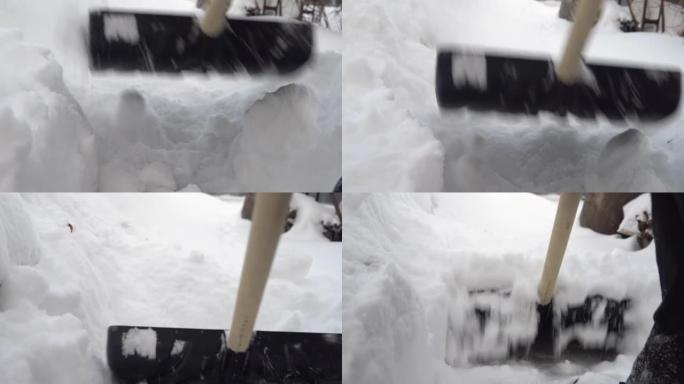 铲子的特写镜头，一个人在院子里用铲子清理雪。俄罗斯的冬天积雪覆盖了院子