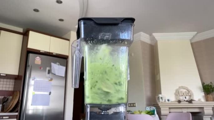搅拌器罐子里旋转的绿色冰沙