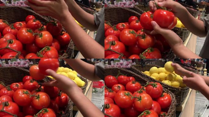 女人的手在市场上拿了几个西红柿