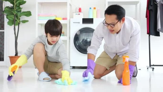 亚洲父子互相帮助清洁地板，用于日常琐事和家政服务