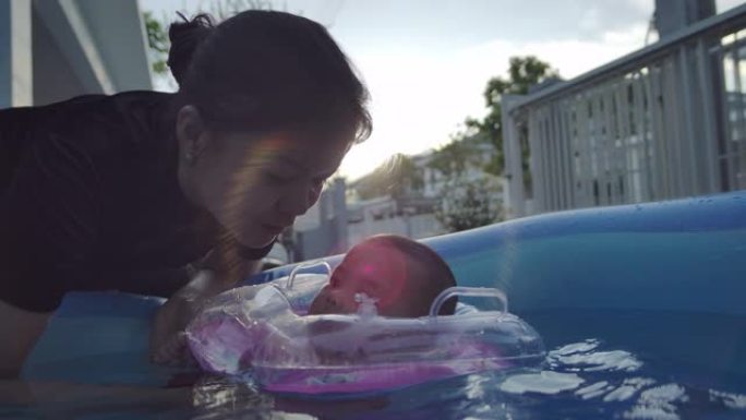 一个男婴和他的母亲在游泳池里玩耍