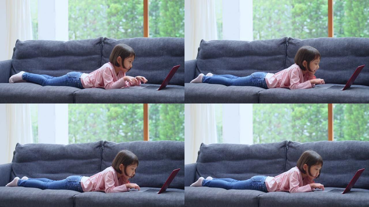 亚洲女孩在沙发上使用笔记本电脑