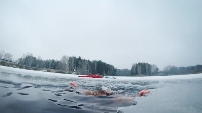 冬季游泳。年轻人在冬季湖中游泳