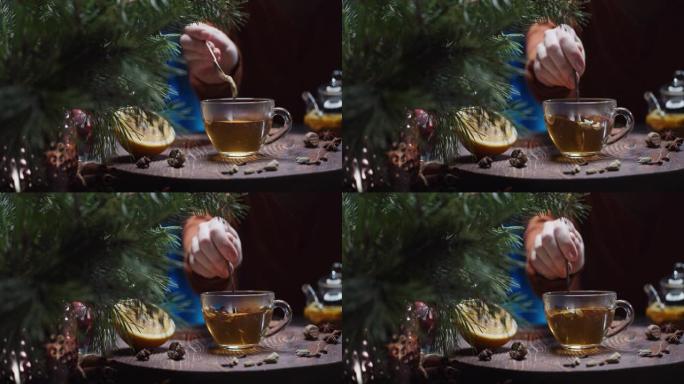 人类的手正在准备带有橙色，肉桂和豆蔻的圣诞节风味茶