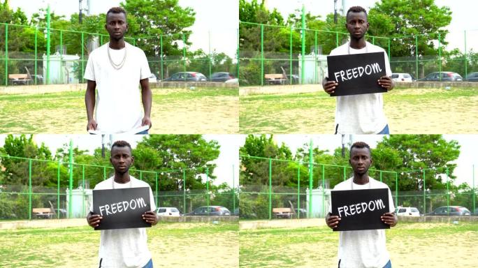 非洲青年抗议者手持纸板“自由”