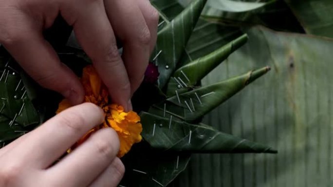 孩子们一起在家制作kathong (用香蕉叶和花朵制成，漂浮在河中祈祷和感谢)，为夜间做准备。