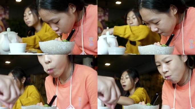 快乐的亚洲女孩吃寿司和鲑鱼生鱼片放在日本餐厅，生活方式理念。
