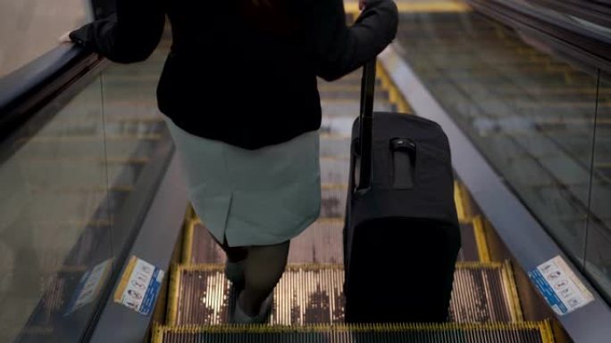 商务女性旅行者在机场步行拉手推车