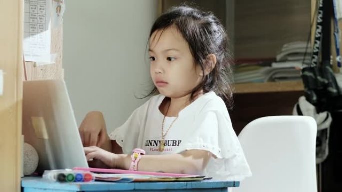 亚洲女孩在家使用笔记本电脑时打喷嚏，家庭教育理念。