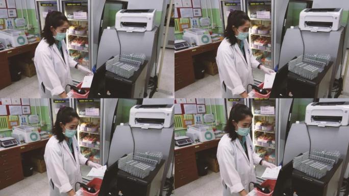 医疗技术人员正在献血室内使用血液分析机。