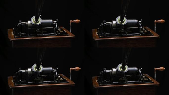经典爱迪生留声机在黑色录音棚背景下通过喇叭播放音乐。复古复古机器重现听音乐的声音。特写。慢动作