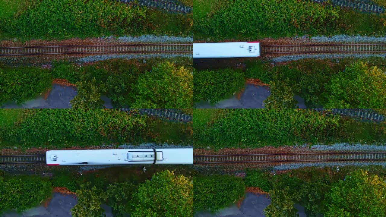 白色旅客列车在铁轨上经过。空中俯视图。