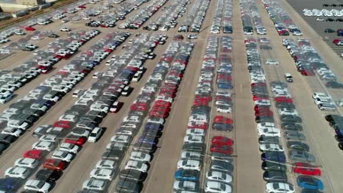 鸟瞰图，无人机在停车场停放的大量汽车上方。它们由4K透明塑料屋顶保护