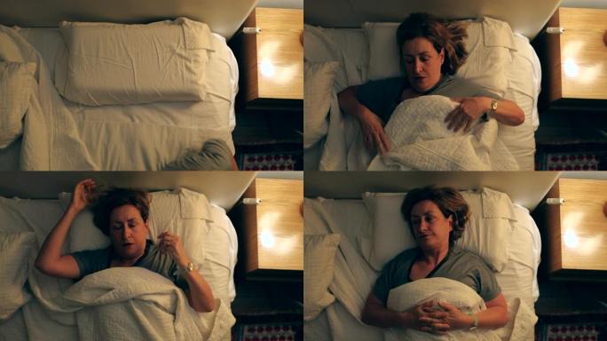 年长的女人晚上睡觉前躺在床上，试图在毯子下放松