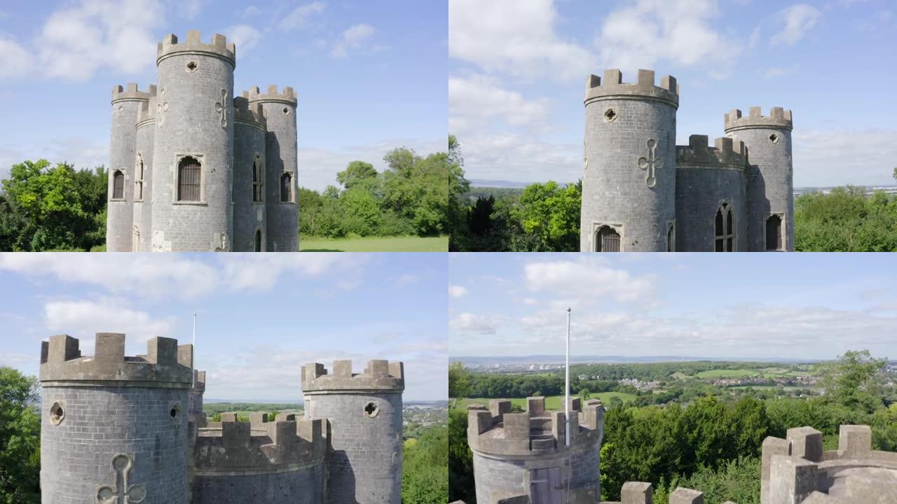 在阳光明媚的日子里，空中移动超过18世纪的哥特式英国愚蠢城堡，有三座炮塔，在阳光明媚的日子里，远处可