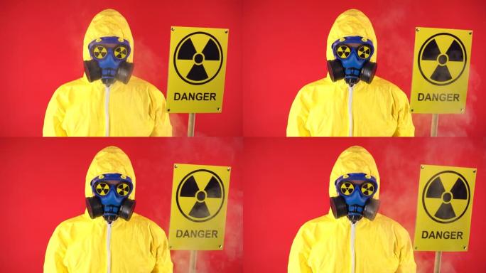 一个穿着化学防护服的男人，戴着带有辐射海报的防护面具。隔离，工作室拍摄。红色背景上的辐射危害概念。周