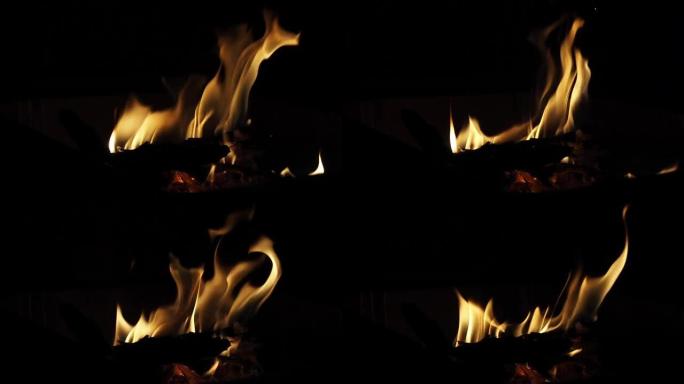 火焰上的黑色，美丽的火焰火焰在黑色的背景纹理。壁炉的慢动作移动。黄颜色温暖炉边。