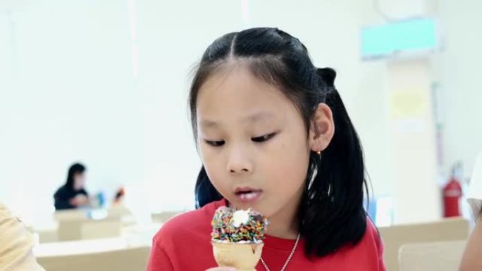 快乐的亚洲儿童在美食广场一起吃冰淇淋蛋卷，生活方式理念。